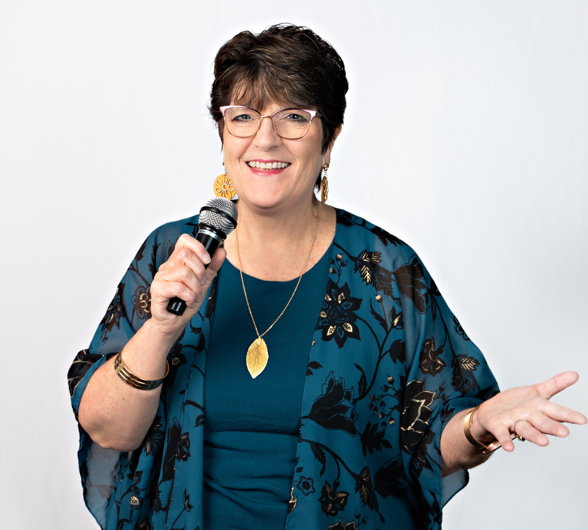 Cyndi Thomsen smiling and speaking with a microphone